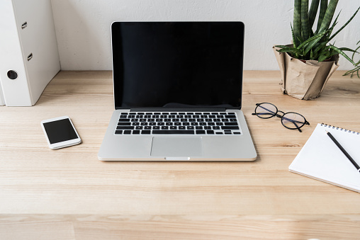 workplace with laptop computer and supplies in modern office